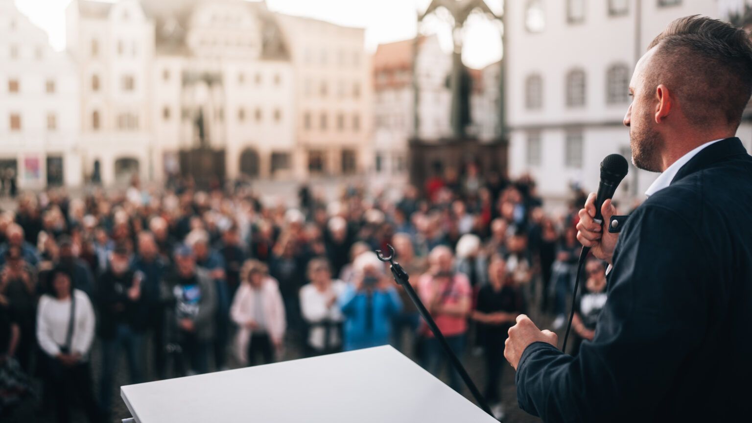 Ulrich Siegmund auf einer Bühne vor zahlreichen Besucherinnen und Besuchern